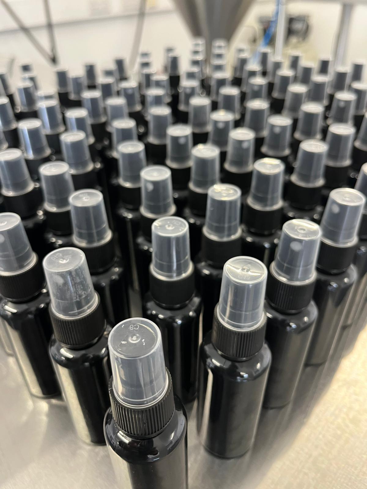 Finished black spray bottles staged after filling - Fragrance and personal care runs.